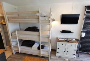 a room with bunk beds and a desk and a tv at Le balcon de villard in Villard-de-Lans