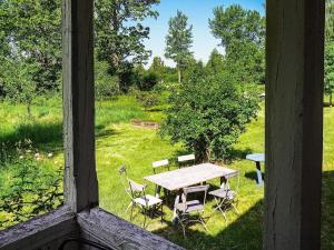 OdensbackenにあるHoliday home ODENSBACKEN IIの窓からの景色を望む芝生のテーブルと椅子