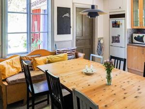 cocina y comedor con mesa de madera en Holiday home ODENSBACKEN II, en Odensbacken