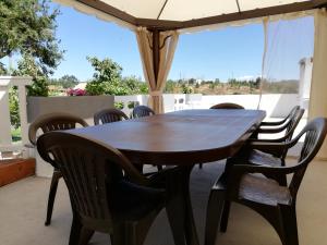 a table and chairs under an umbrella on a patio at Mondalva Guesthouse in São Pedro de Alva