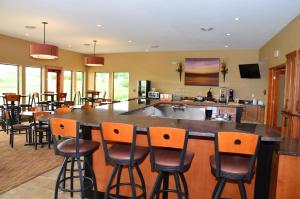 a large kitchen with a bar with chairs and a counter at Cobblestone Inn & Suites - Newton in Newton