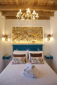 a bedroom with a bed and a chandelier at Cafofos da Zeta in Setúbal