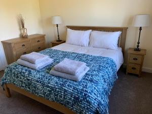 a bedroom with a bed with two pillows on it at Wallaby’s in Durness