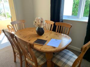 a wooden table with a vase of flowers on it at Wallaby’s in Durness