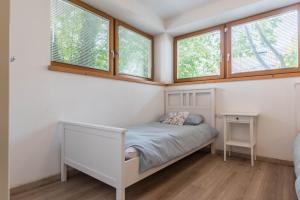 una piccola camera con un letto e due finestre di Casa Weekend a Revò