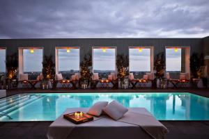 a hotel swimming pool with a table and chairs at Mondrian Los Angeles in West Hollywood in Los Angeles