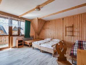 a bedroom with two beds in a room with wooden walls at U SKUPNIÓW Gliczarów Górny in Biały Dunajec