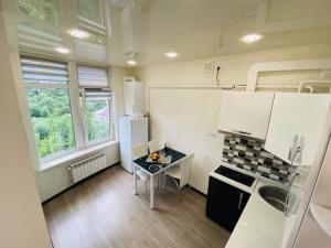 Il comprend une petite cuisine équipée d'une table et d'un réfrigérateur. dans l'établissement Apartment modern style, à Trouskavets