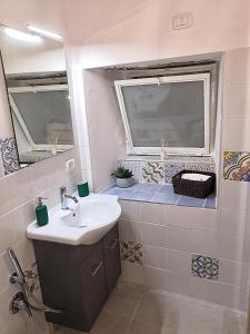 een badkamer met een wastafel en een raam bij Il Ronco di Archimede in Siracusa