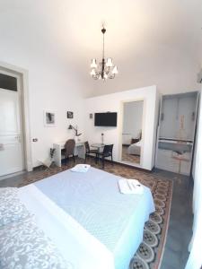 - une chambre blanche avec un grand lit et une télévision dans l'établissement Sicily Sweet Home, à Palerme