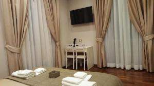 Un dormitorio con una cama, una mesa y un televisor. en Hotelier 51, en Roma