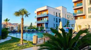 a building with a swimming pool and palm trees at Green Hills Suites in Yalova