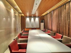 a conference room with a long table and red chairs at Jinjiang Inn East Siming Road in Higher Education Park , Ningbo in Ningbo