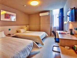 a hotel room with two beds and a desk at Jinjiang Inn East Siming Road in Higher Education Park , Ningbo in Ningbo