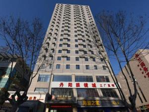 a tall white building with chinese writing on it at JinJiang Inn Pinshang Suqian Shuyang Renming Roa in Suqian