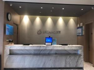 a lobby with a desk with a laptop on it at JinJiang Inn Pinshang Suqian Shuyang Renming Roa in Suqian +18 photos