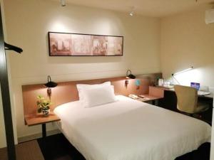 Un pat sau paturi într-o cameră la Jinjiang Inn Select Beijing Pingguoyuan Metro Station