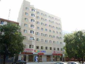 a large white building with cars parked in front of it at Jinjiang Inn Yingkou Port Authority Bayuquan Century Plaza in Yingkou