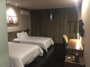 a hotel room with two beds and a television at Jinjiang Inn Select Jining Huoju South Road Branch in Jining
