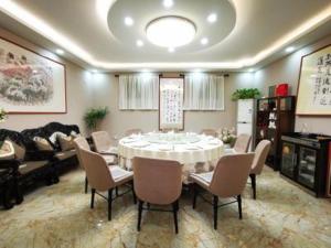 uma sala de jantar com uma mesa branca e cadeiras em Jinjiang Inn select JiNing Qufu Scenic Region North Gulou Street, Jining em Jining