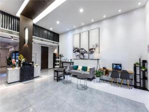 a lobby with a couch and chairs in a building at JinJiang InnSelect Suzhou Shengze Shunhuxilu Hotel in Suzhou