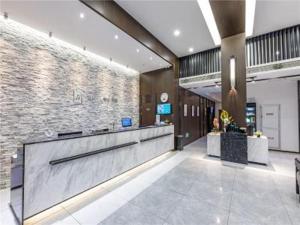 a lobby with a reception desk in a building at JinJiang InnSelect Suzhou Shengze Shunhuxilu Hotel in Suzhou