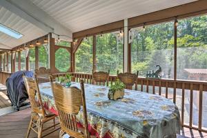 una veranda riparata con tavolo e sedie di 5 Mi to Camelback Henryville Home with Hot Tub! a Henryville