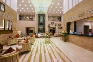 vestíbulo con lámpara de araña, mesas y sillas en Best Western Plus Fursan en Riad