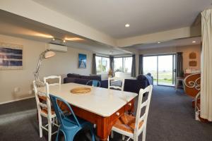 a dining room and living room with a table and chairs at The Lookout Spacious Stunning Views in Kaikoura