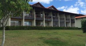 Un gran edificio con césped delante. en Flat Monte Castelo - Gravatá, en Bezerros