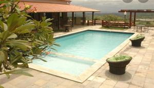 una piscina en un patio con una casa en Flat Monte Castelo - Gravatá, en Bezerros