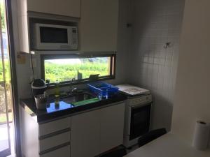 uma cozinha com um lavatório e um micro-ondas em Flat Monte Castelo - Gravatá em Bezerros