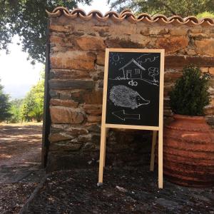 um sinal de quadro em frente a uma parede de pedra em Casa do Ouriço em Figueiró dos Vinhos