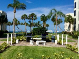 um parque com palmeiras, uma mesa e bancos em Island House Beach Resort 36 em Point O'Rocks