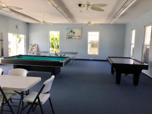 a billiard room with two pool tables and chairs at Island House Beach Resort 36 in Point O'Rocks