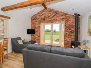 a living room with a couch and a fireplace at Sunrise Stable in Spalding