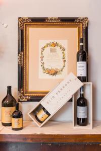 a shelf with three bottles of wine and a picture at Albergo Ristorante San Giors in Turin