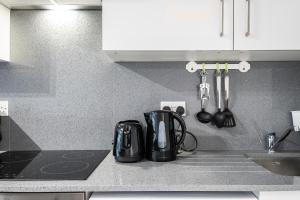 a kitchen counter with a toaster and utensils at Securematics Kings Studio Apartments in London