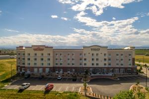 a hotel with a parking lot in front of it at Hawthorn Extended Stay by Wyndham Loveland in Johnstown