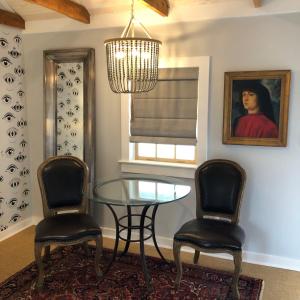a dining room with a glass table and two chairs at The Quarters at Pier450 in Lexington Park