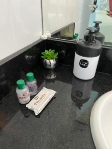 - un comptoir de salle de bains avec un lavabo et un distributeur de savon dans l'établissement Hotel Macapaba, à Macapá