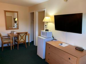 a hotel room with a large flat screen tv on the wall at New Relax Inn Bridgeview in Bridgeview
