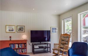 ein Wohnzimmer mit einem Flachbild-TV und Stühlen in der Unterkunft Beautiful Home In Tvedestrand With Ethernet Internet in Tvedestrand