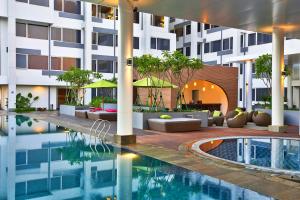 a hotel with a swimming pool in front of a building at Mercure Serpong Alam Sutera in Serpong