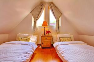 two beds in a attic room with a window at Koh Chang Beach Front 5 Bedroom Villa in Ko Chang