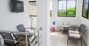 a room with chairs and a table and a tv at Hotel Las Margaritas Alojamientos in Barranquilla
