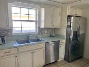 a kitchen with white cabinets and a stainless steel refrigerator at Island House Beach Resort 9 in Siesta Key