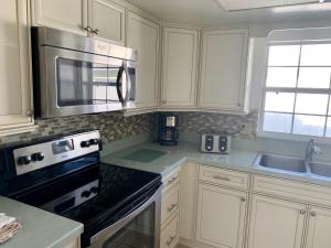 a kitchen with white cabinets and a stove top oven at Island House Beach Resort 9 in Siesta Key