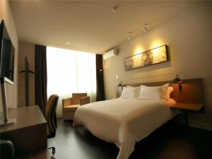 een hotelkamer met een groot bed en een raam bij Jinjiang Inn Select Wuxi Nanchang Street Huaqing Bridge Metro Station in Wuxi