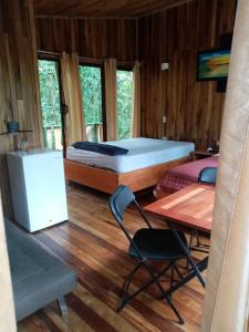 a room with a bed and a table and chairs at The Green Tree Lodge in Monteverde Costa Rica